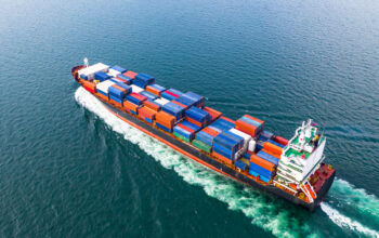 Aerial view cargo container ship sailing, container cargo ship in import export and business logistic and transportation of international by container ship in the open sea.